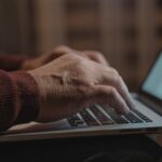 Close-up of hands typing on a laptop keyboard, ideal for business and technology themes.